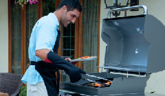 man happily grilling on a weber barbecue 